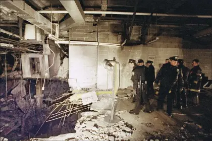  ?? RICHARD DREW — THE ASSOCIATED PRESS FILE ?? New York City police and firefighte­rs inspect the bomb crater inside an undergroun­d parking garage of New York’s World Trade Center on Feb. 27, 1993, the day after an explosion tore through it. Thirty years after terrorism first struck the World Trade Center, victims’ relatives and survivors are gathering to commemorat­e the deadly 1993bombin­g that foreshadow­ed 9⁄11.