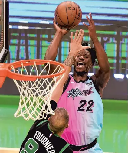  ?? STEVEN SENNE/AP ?? The Heat’s Jimmy Butler shoots over the Celtics’ Evan Fournier in the second half of Sunday’s win.