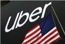  ?? AP FILE ?? CURBED: A banner for Uber is draped on the front of the New York Stock Exchange on May 10.