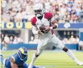  ?? ASHLEY LANDIS/AP ?? QB Kyler Murray evades Rams LB Obo Okoronkwo during the Cardinals’ 37-20 road victory Sunday.