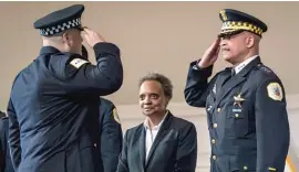  ?? ASHLEE REZIN/SUN-TIMES PHOTOS ?? LEFT: Mayor Lori Lightfoot smiles as First Deputy Supt. Eric Carter salutes a new officer.