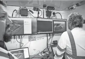  ?? ?? Tye Payne and Kenny Roberts with Texas A&M-Corpus Christi's Lone Star Lone Star Unmanned Aircraft System Center watch a video feed streaming from a drone at Padre Island National Seashore on Thursday.