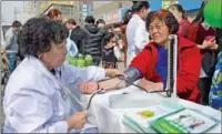  ?? PROVIDED TO CHINA DAILY ?? working at a community healthcare center in Xi’an, Shaanxi province, measures a woman’s blood pressure.
