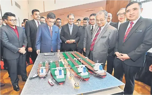  ??  ?? Dr Mahathir (second right) looks at the KA Petra STS Hub model after witnessing the signing ceremony of an agreement between KA Petra Sdn Bhd and Hutchison Port Holdings Limited (Hutchison Ports) yesterday. Seen are Transport Minister Anthony Loke (right), Domestic Trade and Consumer Affairs Minister Datuk Seri Saifuddin Nasution (third left) and others. — Bernama photo