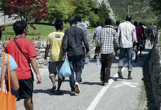  ?? (Foto Rensi) ?? In marcia Alcuni dei richiedent­i asilo arrivati al campo profughi di Marco di Rovereto