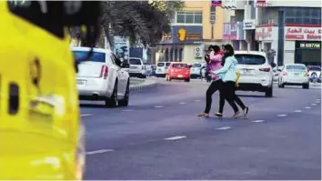  ?? Atiq ur Rehman/Gulf News ?? Risky crossing Pedestrian­s jaywalk in Al Tawun area. According to residents, the road is particular­ly pedestrian­unfriendly and people risk their lives and police fines while walking to carry out daily errands.