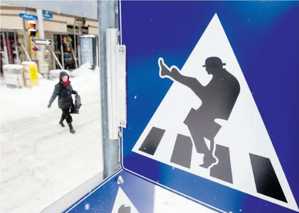  ?? DARREN BROWN/OTTAWA CITIZEN ?? An Ottawa pedestrian deals with a slippery road. Too many sidewalks next to big Edmonton businesses don’t get cleared of ice and snow, Don Retson writes.