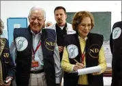  ?? DEBORAH HAKES/ THE CARTER CENTER 2006 ?? FormerU. S. President Jimmy Carter ( left) and hiswife, Rosalynn, visit a polling station during the Palestinia­n parliament­ary elections in Jerusalem in 2006. The Carter Center is taking the unpreceden­ted step to get involved inU. S. elections.