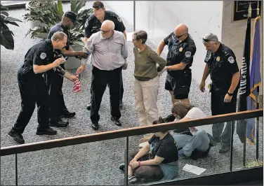  ?? AP/ANDREW HARNIK ?? Capitol Hill police officers arrest a group protesting the Republican health care bill outside the offices of Sen. Dean Heller, R-Nev., in Washington on Monday.