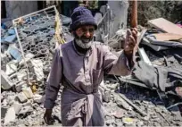  ?? — AFP ?? A man reacts as he walks through the rubble of a collapsed building in the central Gaza Strip.