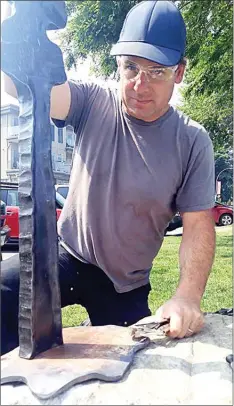  ?? JOE FRIES/Penticton Herald ?? Cranbrook artist Paul Reimer repairs his Tamarack Pond sculpture, which was hit by vandals just two months after it was installed along the Penticton waterfront as part of a larger public art exhibit.