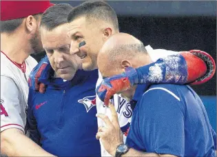  ?? CP PHOTO ?? Toronto Blue Jays’ Troy Tulowitzki, centre, is helped off the field by trainers Mike Frostad, left, and George Poulis after he injured himself awkwardly running across the first base bag in the third inning of their American League MLB game against the...