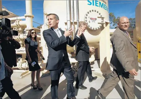  ?? Al Seib Los Angeles Times ?? ERIC GARCETTI, center, tours an Arleta facility with DWP officials last year. Los Angeles’ mayor had told Angelenos that the department must “earn back your trust” before he would let it raise rates to pay for repairs to the city’s crumbling pipes and...