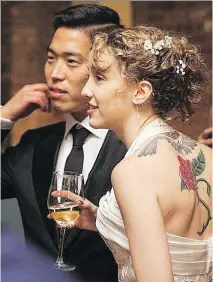  ?? MILES RANNO ?? Lilly Dancyger, the writer, and her husband, Soomin Dancyger, at their wedding. The bride had her dress altered to better show off her back tattoo.