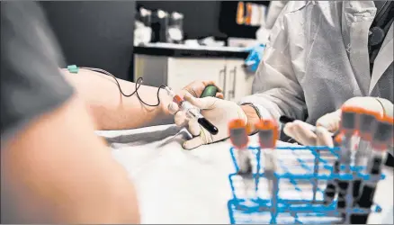  ?? CHANDAN KHANNA/GETTY-AFP ?? Laymis Alvarez, right, takes blood samples from Heather Lieberman in August during a COVID-19 vaccine study in Florida.