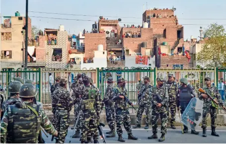  ?? PTI ?? Security personnel stand guard in an area where clashes broke out between groups against and those supporting the Citizenshi­p (Amendment) Act in north-east Delhi on Tuesday. —