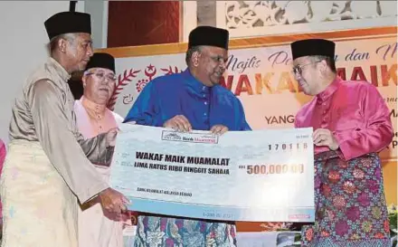  ?? PIC BY SYAMSI SUHAIMI ?? Regent of Kelantan and Maik president Tengku Dr Muhammad Faiz Petra (right) receiving a mock cheque of RM500,000 from Bank Muamalat Malaysia chief executive officer Datuk Mohd Redza Shah Abdul Wahid (second from right) in Kota Baru yesterday. With them...
