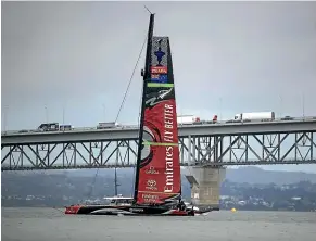  ?? STUFF ?? Team New Zealand with their new soft wingsail raised in front of Auckland’s Harbour Bridge yesterday.