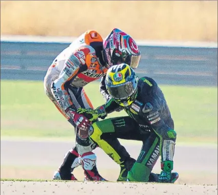  ?? FOTO: EFE ?? Marc Márquez ayuda a levantarse de la grava a Pol Espargaró. Se vieron envueltos en una caída por un error de una bandera