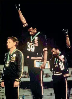  ??  ?? Tommie Smith, centre, and John Carlos, right, were sent home for giving the black power salute at the 1968 Olympic Games.