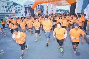  ??  ?? Runners head to the street after the flag-off of T-RUN 2.0 outside Crown Towers. — Photos by Muhammad Rais Sanusi