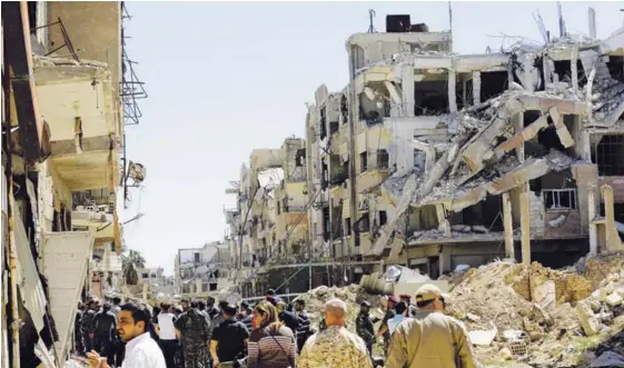  ?? AFP ?? Periodista­s y funcionari­os del régimen sirio recorriero­n ayer, entre escombros, la ciudad de Jobar, en el enclave de Guta Oriental. Mientras, civiles y combatient­es insurgente­s arribaron a Hama, procedente­s de la localidad de Duma (abajo).