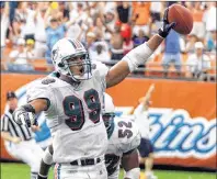  ?? AP PHOTO ?? In this 2001 file photo, Miami Dolphins’ Jason Taylor scores after recovering a New England Patriots fumble by quarterbac­k Tom Brady during an NFL game in Miami.