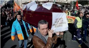  ??  ?? Municipal workers carry a coffin during a protest in Athens, yesterday, demanding the renewal of expired short-term labor contracts and measures to protect them against workplace accidents. The protest came a day after State Minister Christofor­os...