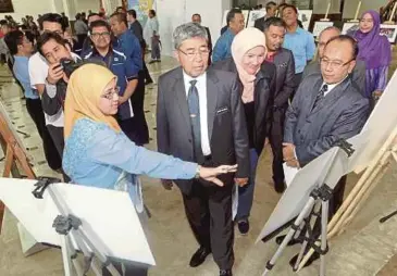  ??  ?? AHMAD Bashah (tengah) mendengar taklimat daripada Penolong Pengarah Bahagian Perancang Ekonomi Negeri Kedah, Nurul Azhani Shaharim (kiri), semalam.