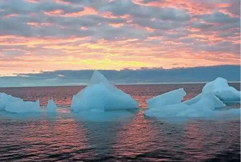  ?? CANADIAN PRESS FILES ?? Ice chunks float in the Arctic Ocean as the sun sets near Barrow, Alaska in 2006. Scientists have found the world’s first large-scale area of acidified water in the open ocean in the seas of the western Arctic. They say the area of acidified water in...