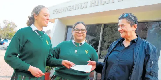  ?? Photo / Bevan Conley ?? Whanganui High School prefects Aranga Molijn (left) and Miriama Joseph hand over the cheque to Women’s Refuge manager Yvonne Denny.