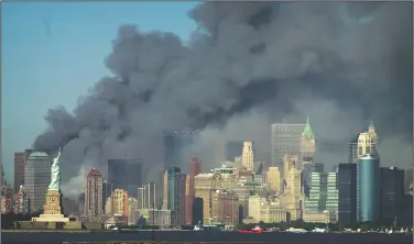  ?? (AP/Daniel Hulshizer) ?? Thick smoke billows into the sky from the area behind the Statue of Liberty where the World Trade Center was on Sept. 11, 2001.