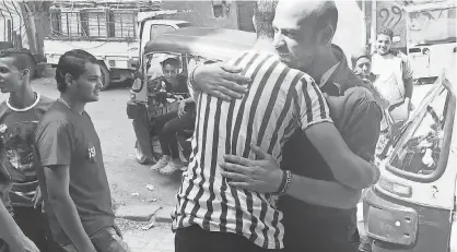  ?? STEVEN SEDRAK ?? John Insan hugs a tuk tuk driver before one of his workshops on sexual harassment, which he organized after he saw how it affected the women in his family.