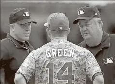  ?? Alex Gallardo / The Associated Press ?? San Diego Padres manager Andy Green talks with umpires Chris Segal (left) and Joe West in an attempt to overturn their ruling to allow Los Angeles’ Curtis Granderson second base on an error during the fourth inning of Sunday’s game in San Diego....