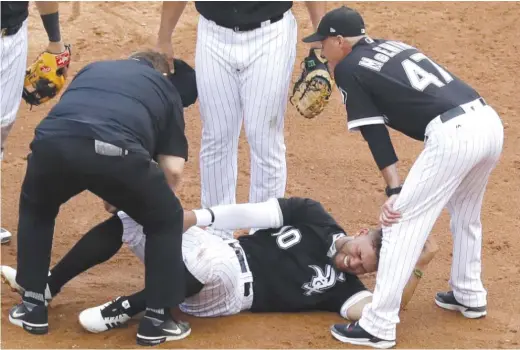  ?? NAM Y. HUH/AP ?? Sox second baseman Yoan Moncada is checked by trainer Herm Schneider after being hit on the inside of his right knee by Reynaldo Lopez’s pickoff throw. Moncada was forced to leave the game.