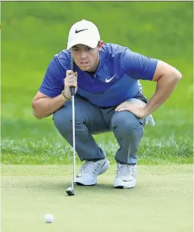  ??  ?? Try, try, try again: Rory Mcilroy using his third putter of the weekend yesterday