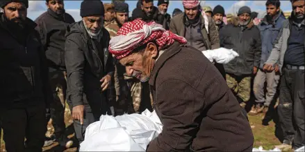  ?? GHAITH ALSAYED/AP FILE ?? Mourners bury family members who died in a devastatin­g earthquake in the town of Jinderis, Aleppo province, Syria, on Feb. 7. The quake has brought down thousands of buildings and killed more than 39,00 in both countries, with death tolls still rising.