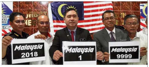  ??  ?? Nice plates: Loke (centre) launching the ‘Malaysia’ series vehicle registrati­on numbers at the JPJ office in Seremban.