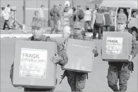  ?? Dolores Ochoa Associated Press ?? SOLDIERS deliver ballot boxes in Quito, Ecuador. The nationwide vote to replace President Rafael Correa already seems likely to head to a runoff.