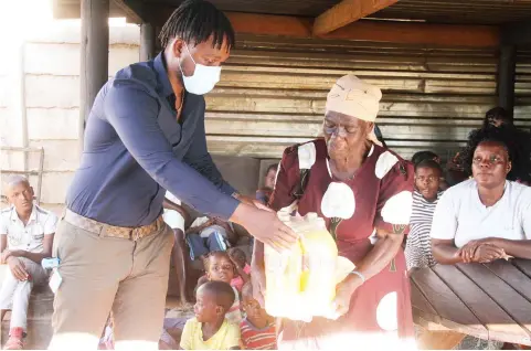  ??  ?? GOOD SAMARITAN . . . Chamu Chibhabha, the captain of the Zimbabwe limited overs team (left), hands over drinks to Mbuya Linnet Gwanzura afterdonat­ing goodies worth thousands of dollars to the Wings of Grace orphanage in Mufakose yesterday