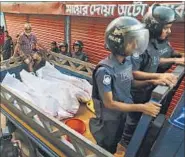  ?? AP PHOTO ?? Bangladesh policemen take away the bodies of suspected militants after a raid in Narayangan­j, near Dhaka, on Saturday.