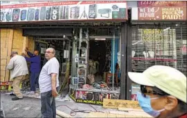  ?? Irfan Khan Los Angeles Times ?? BUSINESSES in downtown Los Angeles attempt cleanup on Saturday after the vandalizin­g and looting that occurred during the previous night’s protest.