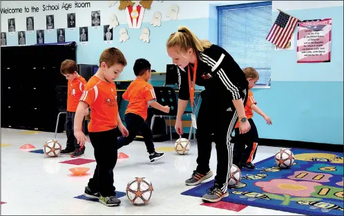  ?? Baltimore Sun/TNS/KIM HAIRSTON ?? Ethan Schultz, 5, receives instructio­n from Megan Kowalewski, a program coordinato­r with Soccer Shots, as she works with a preschool class at Celebree Learning Center in Perry Hall, Md.