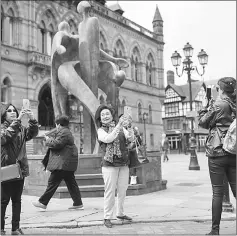  ?? — AFP photo ?? Visitors take photograph­s outside the Town Hall in Chester.