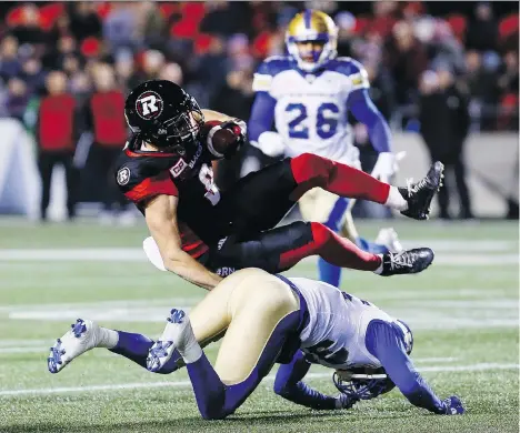  ?? ERROL MCGIHON ?? Ottawa Redblacks wide receiver Jake Harty is tackled by Winnipeg Blue Bombers defensive back Terrence Frederick during CFL action at TD Place in Ottawa on Friday. Ottawa remained atop the Canadian Football League’s East Division standings despite...