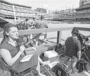  ?? Karen Warren / Houston Chronicle ?? Julia Morales of AT&amp;T SportsNet Southwest reports from inside the third-base photo well on Saturday.