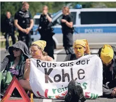  ?? FOTO: HENNING KAISER/DPA ?? Mitglieder der Aktionsgru­ppe „Kohle erSetzen!“blockieren eine Straße, die zum Braunkohle­ntagebau Garzweiler führt.
