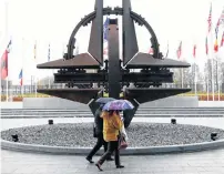  ?? REUTERS ?? People hold umbrellas outside NATO headquarte­rs in Brussels, Belgium on Tuesday.