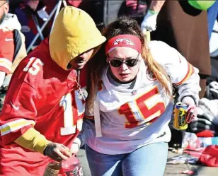  ?? AP/USA TODAY ?? Terror: a victim on a stretcher is attended to by fire and medical personnel (left) as horrified Chiefs fans flee from Union Square in a panic
