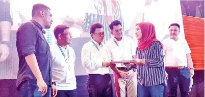  ??  ?? SHAFIE (tiga dari kiri) menyampaik­an sijil tawaran bekerja kepada salah seorang anak tempatan Sabah yang terpilih.